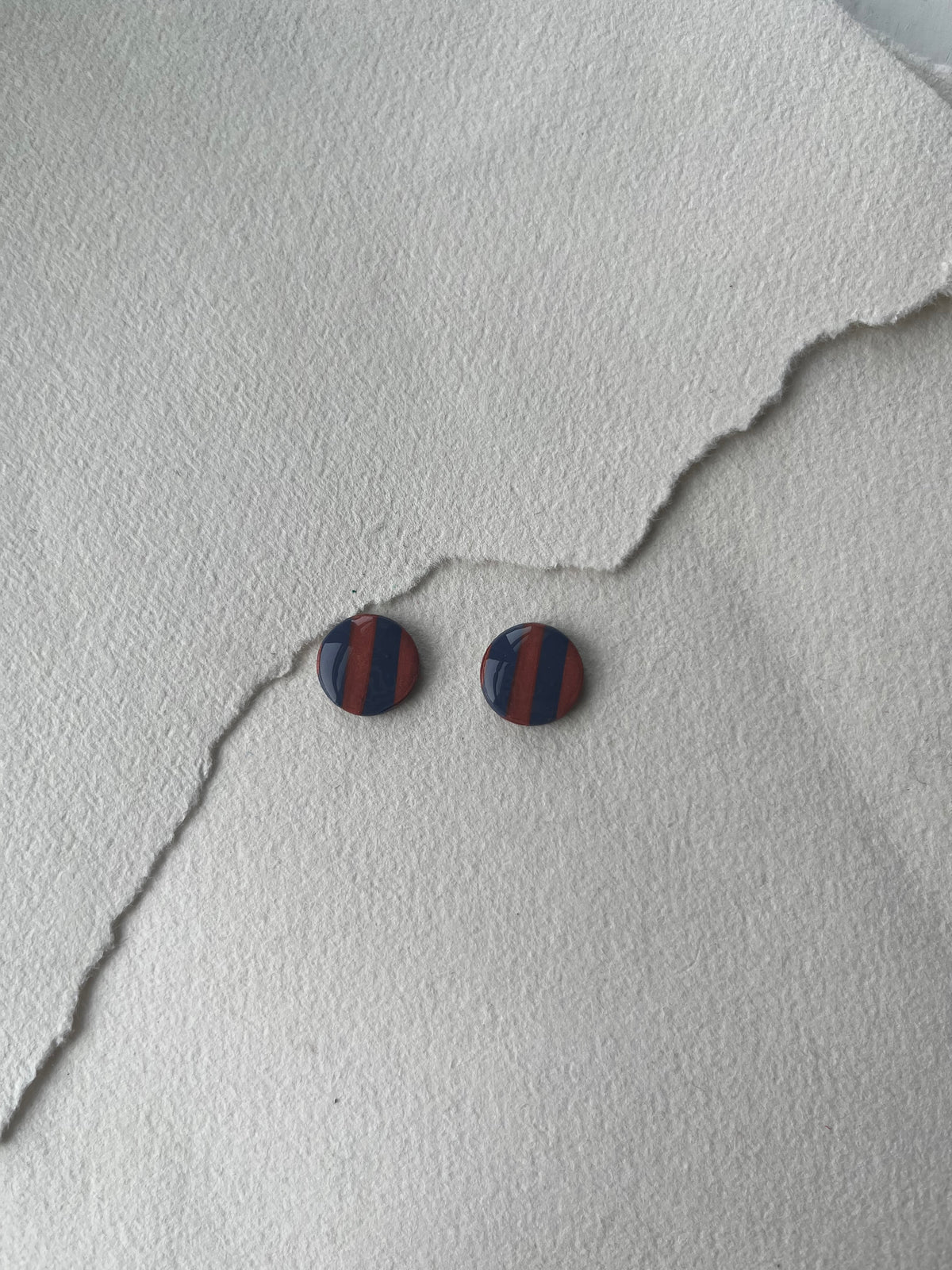 Stribede og tofarvede DOTS ørestikker i akryl, mørk blå / kobber striber, fra Winther Design
