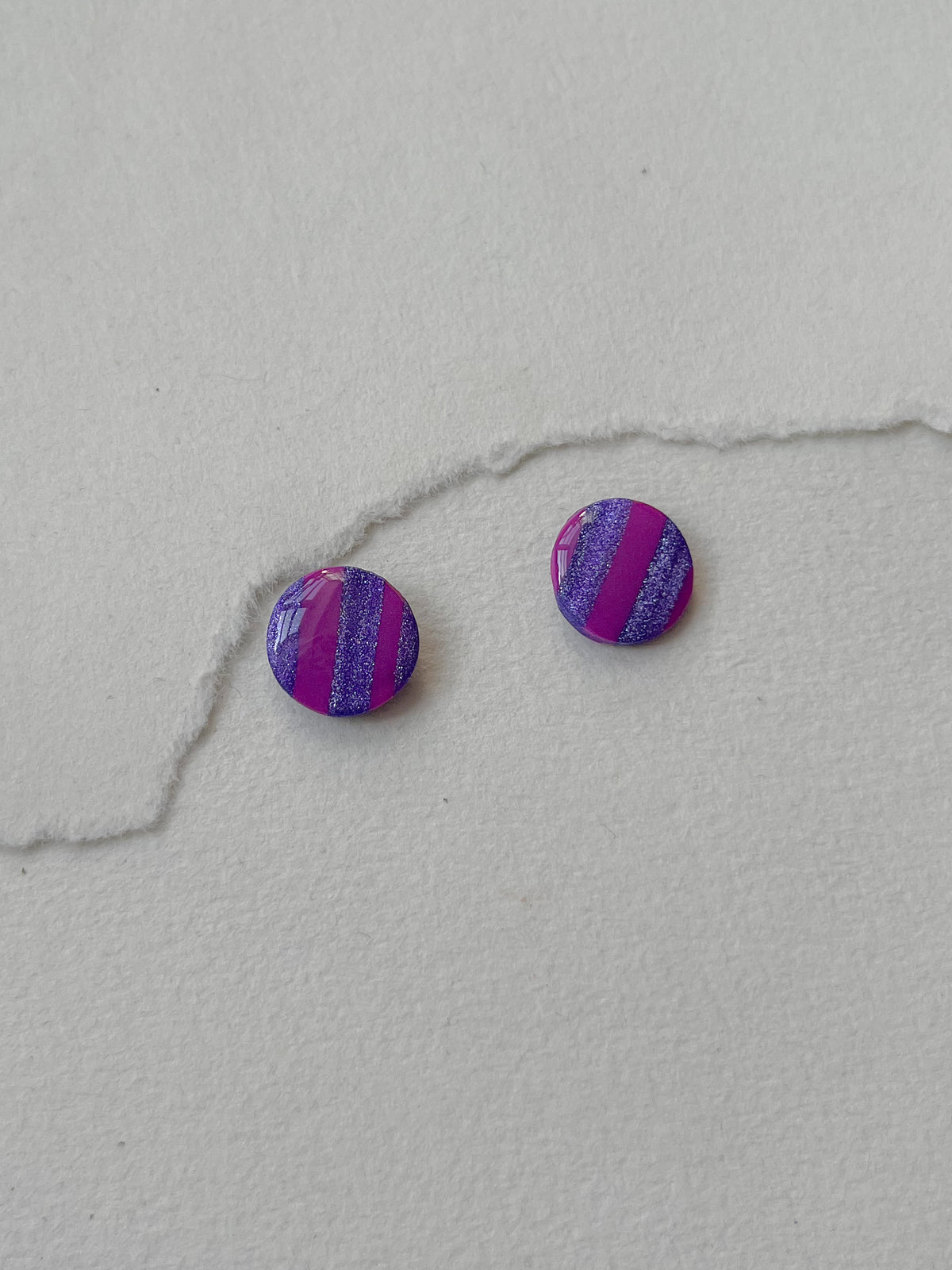 Stribede og tofarvede DOTS ørestikker i akryl, lilla / pink, fra Winther Design