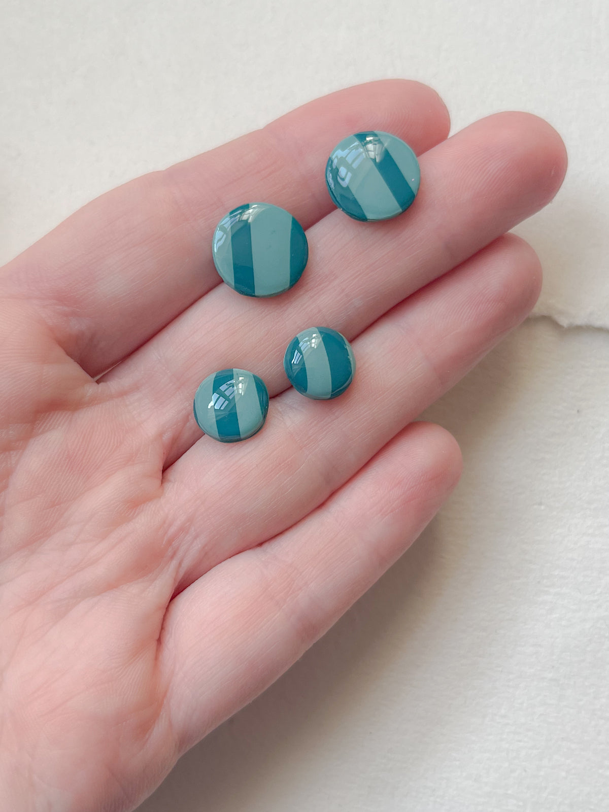 Stribede og tofarvede DOTS ørestikker i akryl, mint / petroleum, fra Winther Design