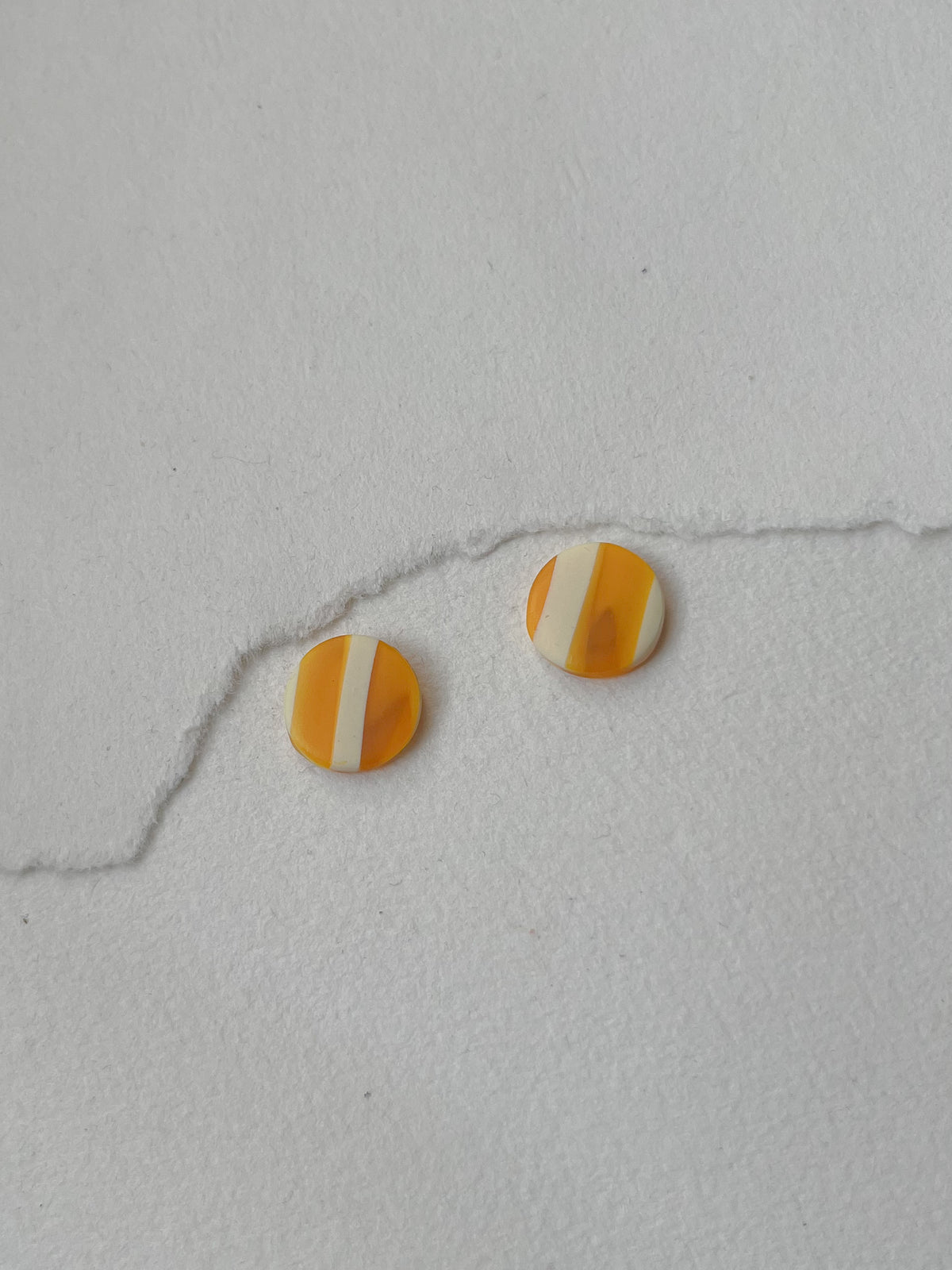 Stribede og tofarvede DOTS ørestikker i akryl, gul / hvid, fra Winther Design